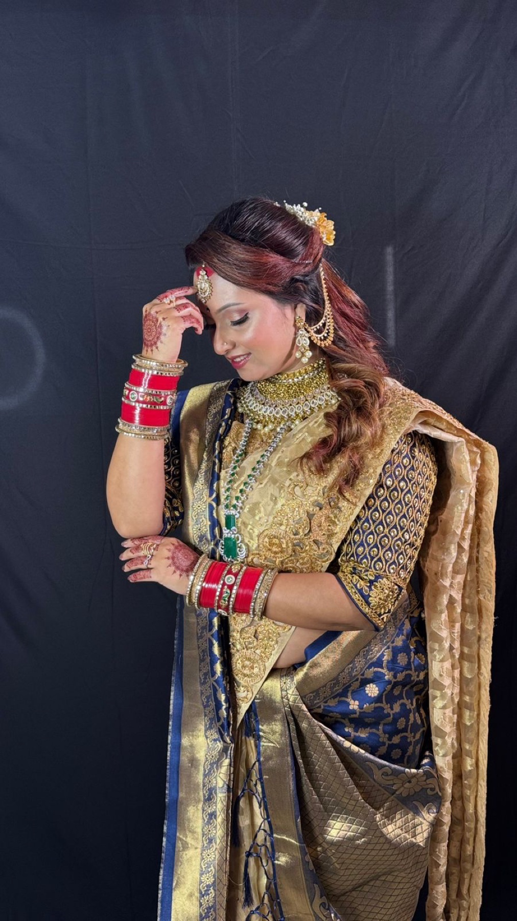 Bride in navy and gold with softly defined eyes and side-swept bridal hair