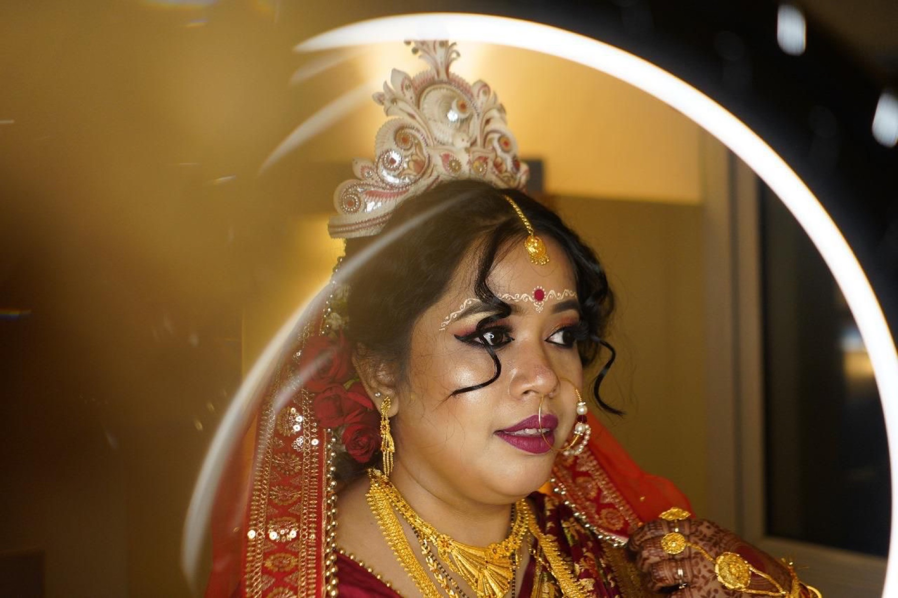Bengali bridal makeup photographed through a softly glowing ring light