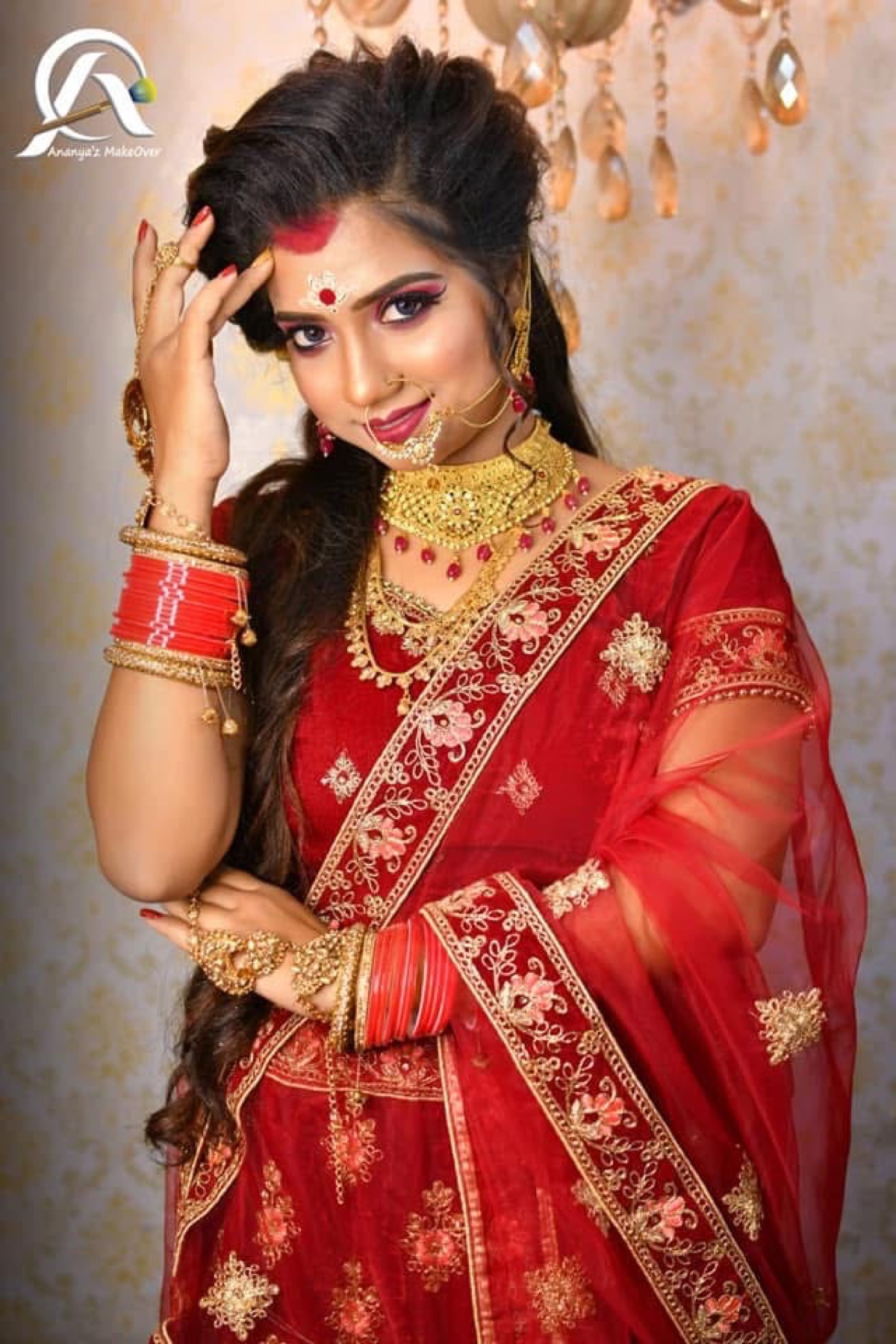 Bride in red with traditional Bengali makeup, jewellery and softly styled hair