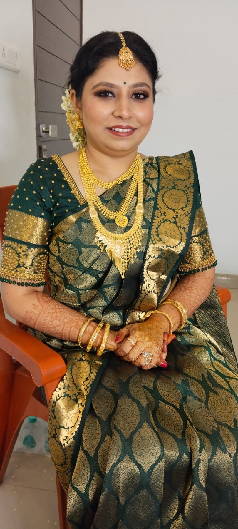 Bride in a green silk saree with polished complexion and defined eyes