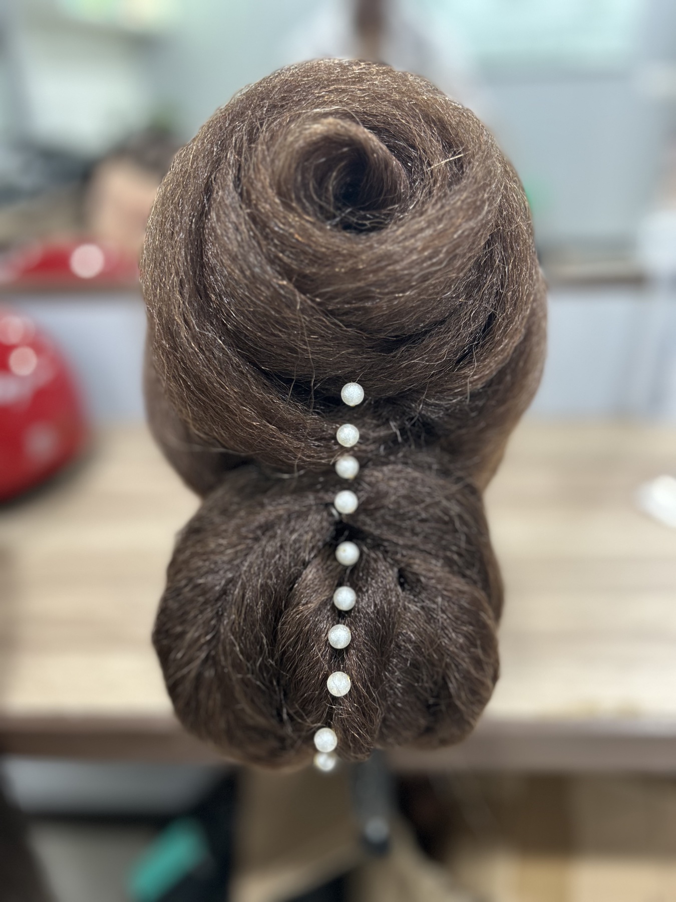 Sculpted bridal updo finished with a delicate line of pearl pins