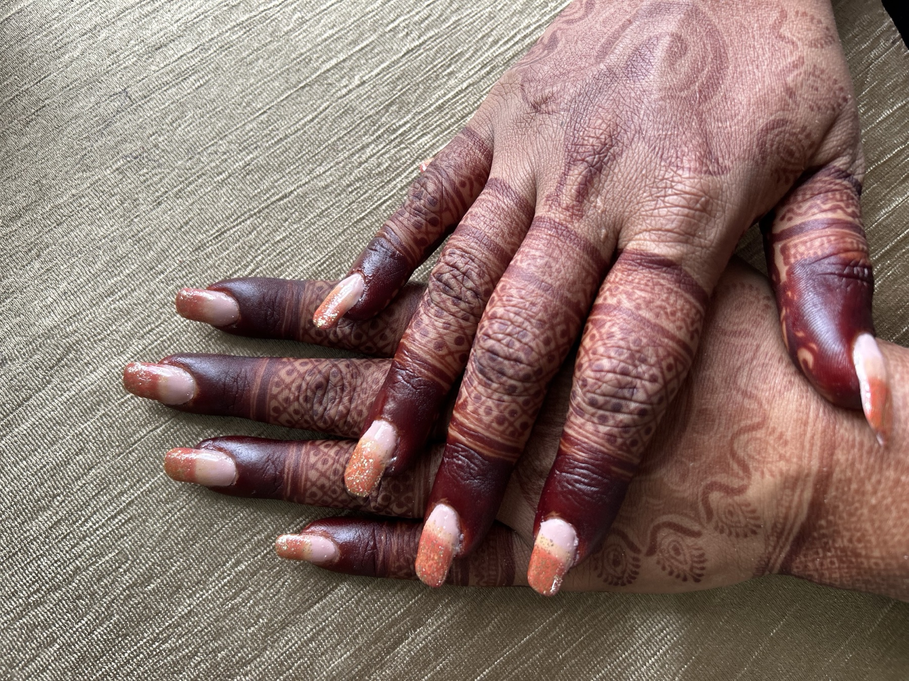 Peach ombre nail extensions on bridal mehndi hands